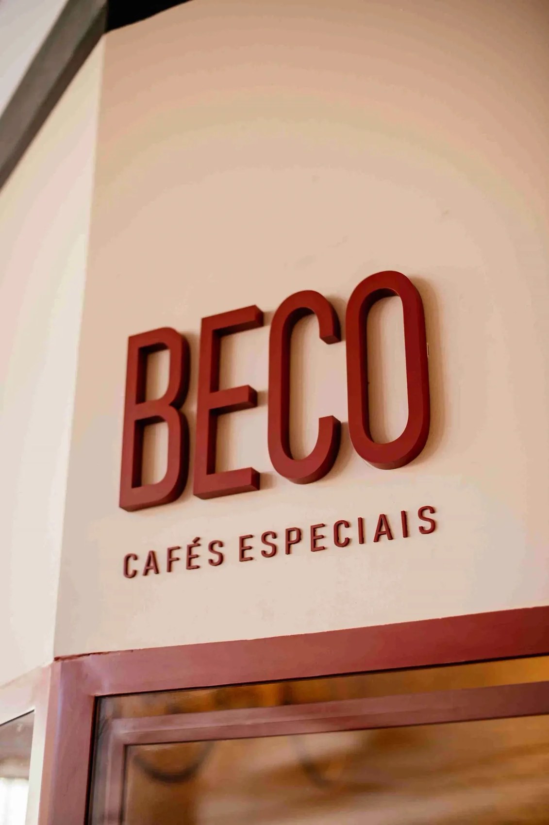 The raised lettering storefront sign above the entrance at Beco Cafés Especiais